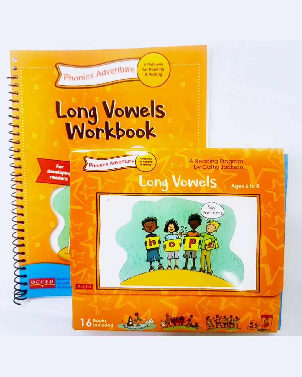 Two 'Long Vowels Workbook' books on a white background