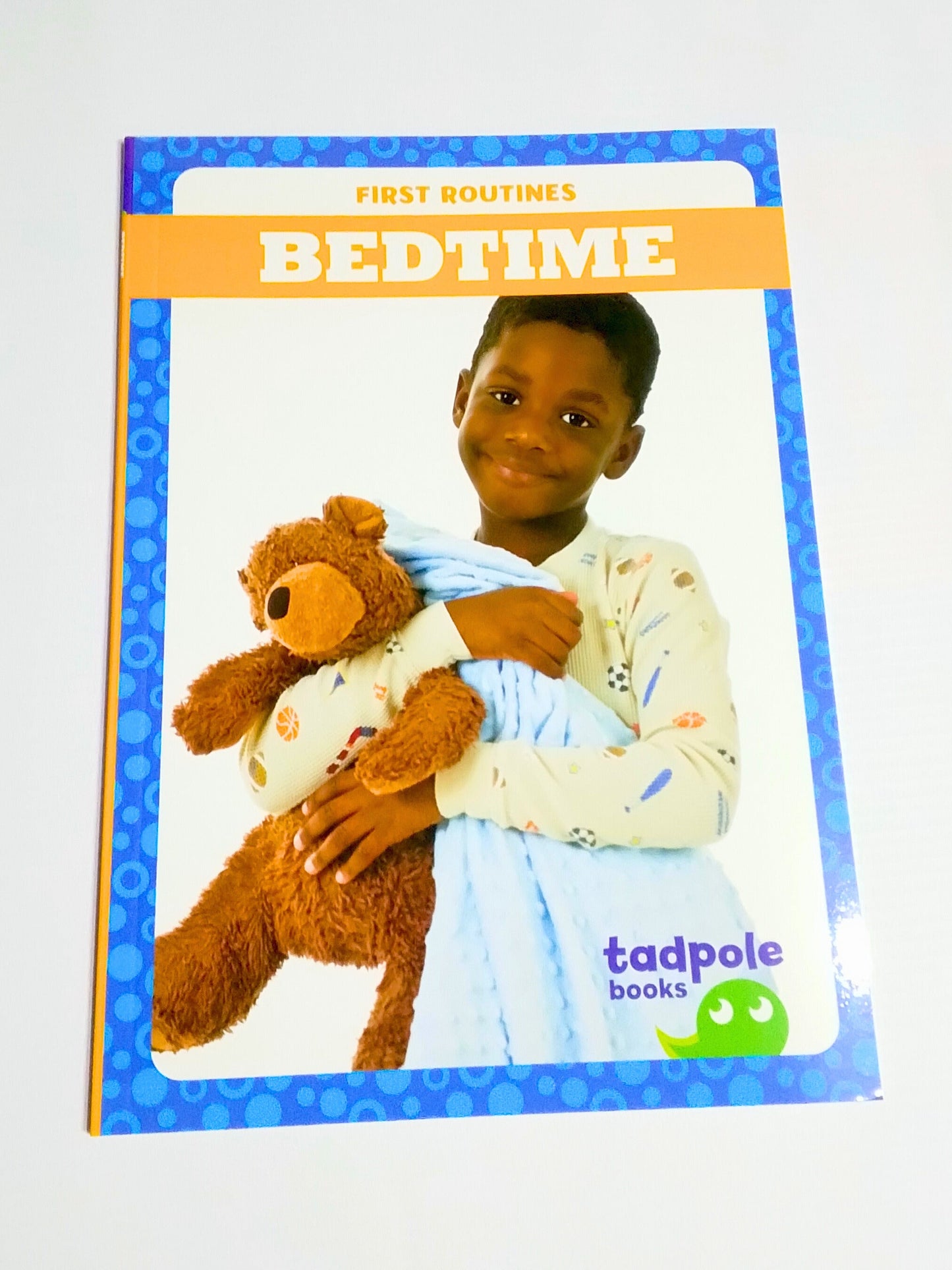 Book titled 'First Bedtime' by Tadpole Books with a child holding a teddy bear on the cover.
