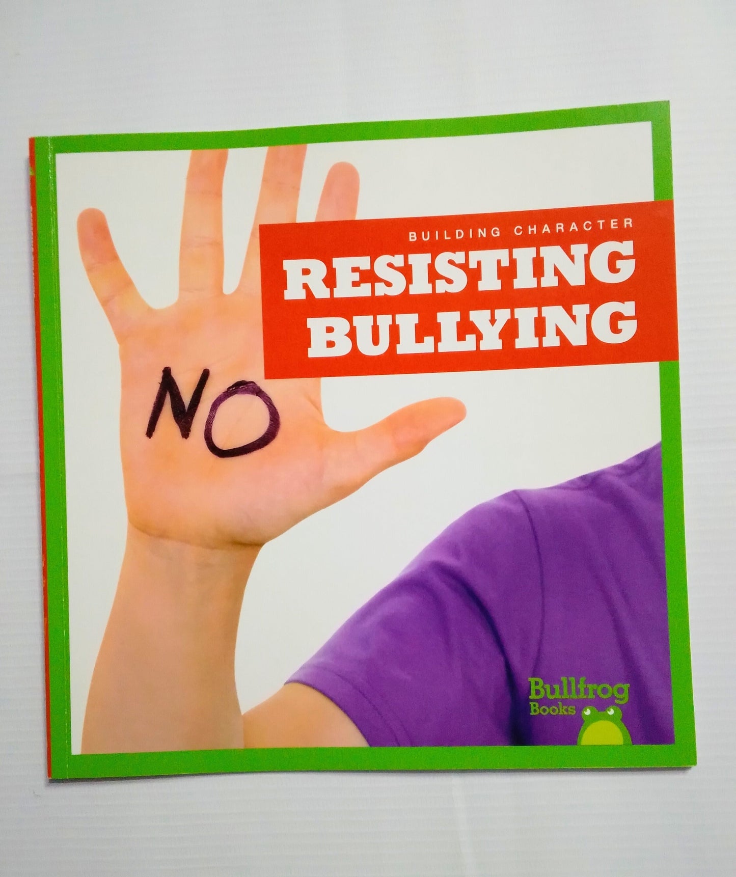 Book cover with a hand holding up a palm showing the word 'No' against a white background.