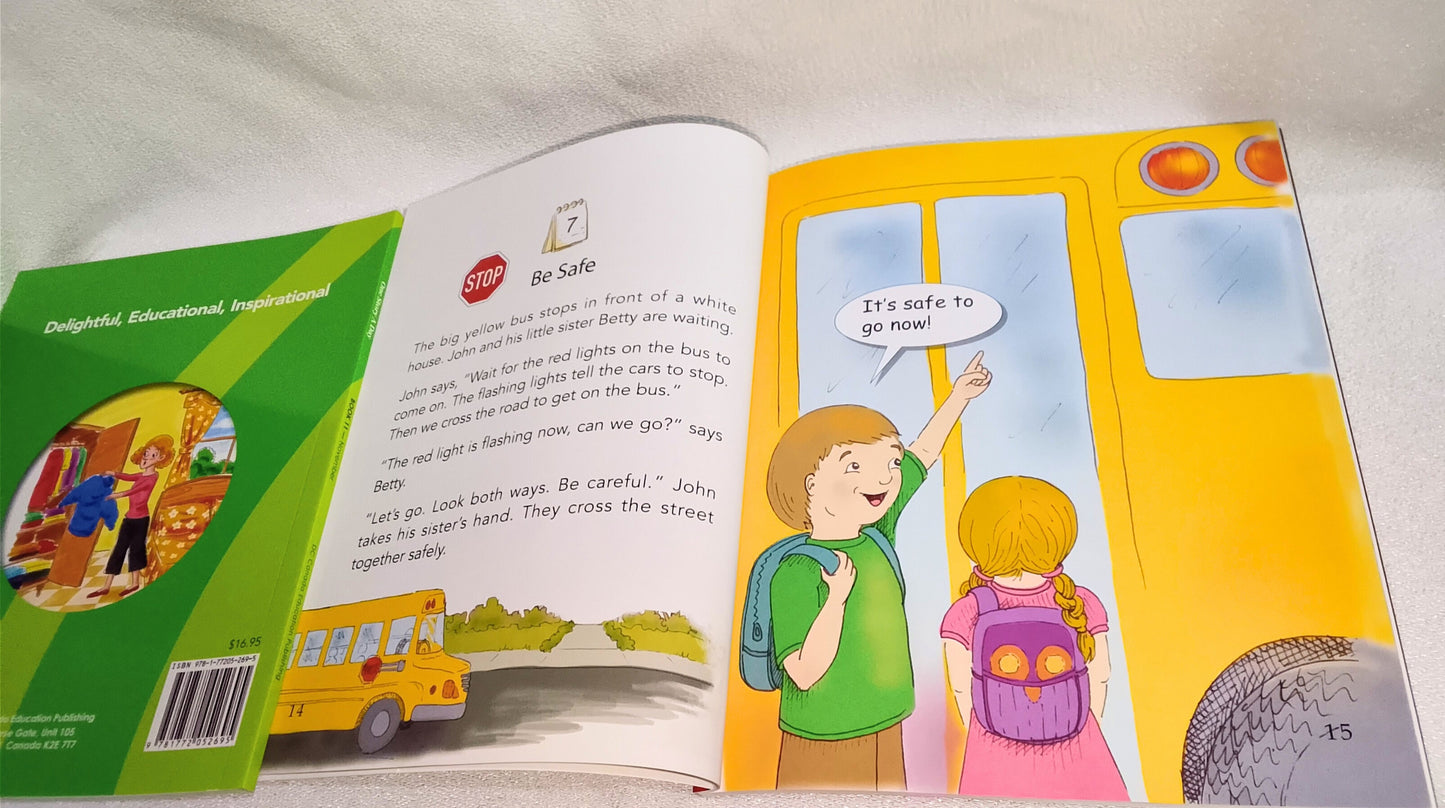 Children's book open to a page with a bus and two children on a white surface